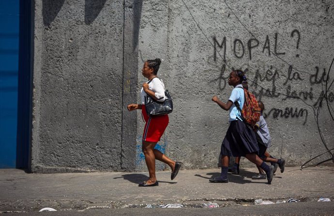 Archivo - 25 February 2025, Haiti, Port-au-Prince: A woman and children flee thier homes during yet another gang attack at Port-au-Prince. Photo: Patrice Noel/ZUMA Press Wire/dpa