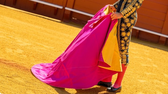 Imagen de recurso de un torero, con su capote, en el albero de un coso taurino.