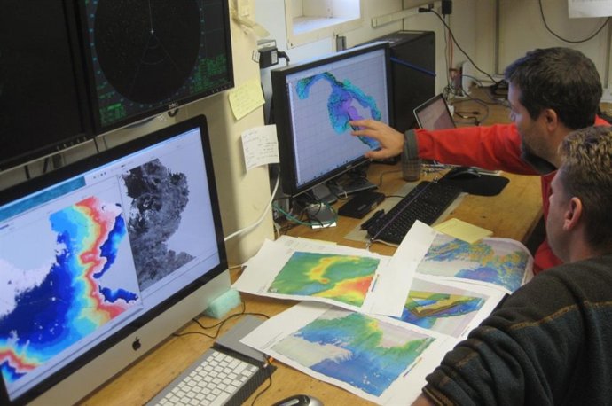 Los científicos codirectores Jasper Konter y Matt Jackson buscan un sitio de muestreo adecuado utilizando datos de montes submarinos recopilados con el sistema de sonar del barco de investigación.