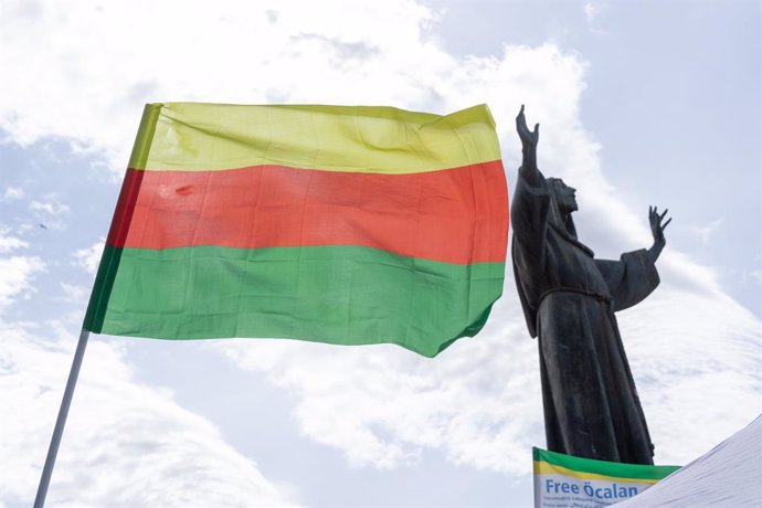 Archivo - 27 de abril de 2024, Roma, Itália: Bandeira curda de Rojava hasteada em frente à estátua de São Francisco de Assis na Piazza San Giovanni, em Roma