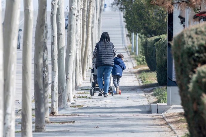 Archivo - Una mujer lleva un carrito de bebé.