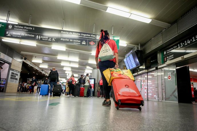 Archivo - Una mujer camina con su equipaje en la estación de Madrid-Puerta de Atocha
