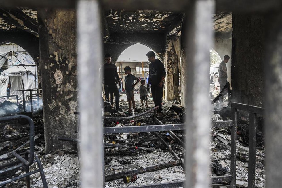 Palestinians inspect the damage after an Israeli strike on a school housing displaced Palestinians in Gaza City on April 23, 2025. 