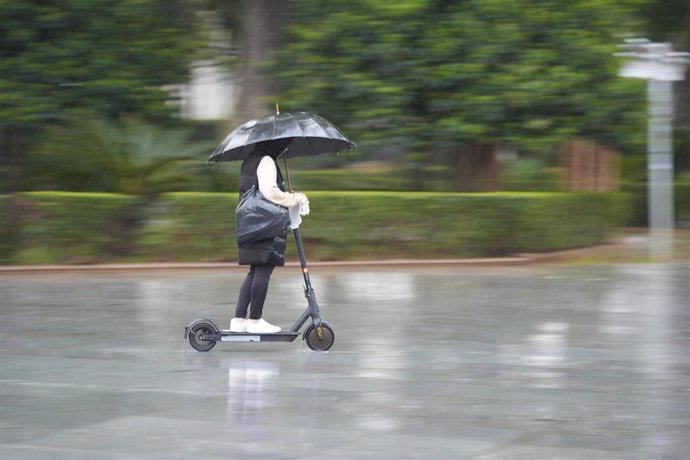 Archivo - Una persona se protege de la lluvia con un paraguas.