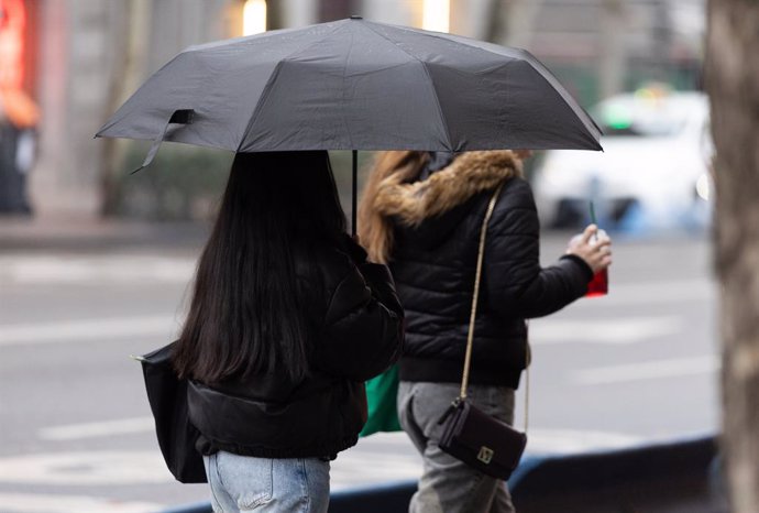Archivo - Personas con paraguas bajo la lluvia durante la llegada de la borrasca ‘Garoé’, a 20 de enero de 2025, en Madrid (España). La AEMET avisa de la llegada de 'Garoé', séptima borrasca con nombre, que dejará lluvias por toda España esta semana Las p