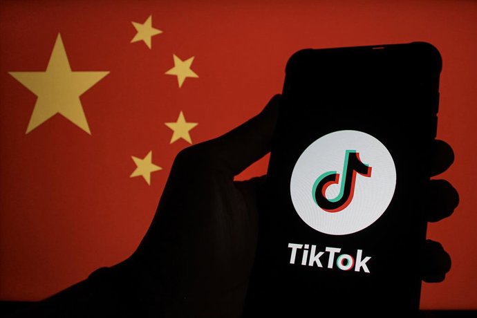 Archivo - Arquivo - 07 de dezembro de 2024, Indonésia, Bandung: O logotipo do TikTok é exibido em um smartphone com a bandeira da China ao fundo. O serviço chinês de hospedagem de vídeos curtos, TikTok, sofreu um revés em sua batalha contra a lei dos EUA 