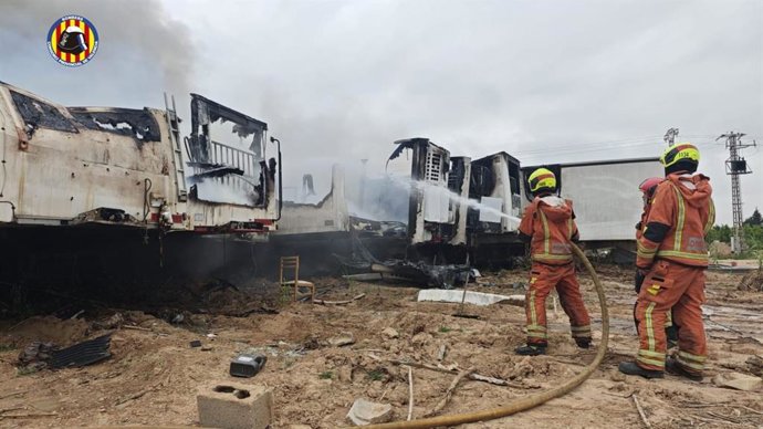 Bomberos trabajan para extinguir un incendio en una campa de Carlet