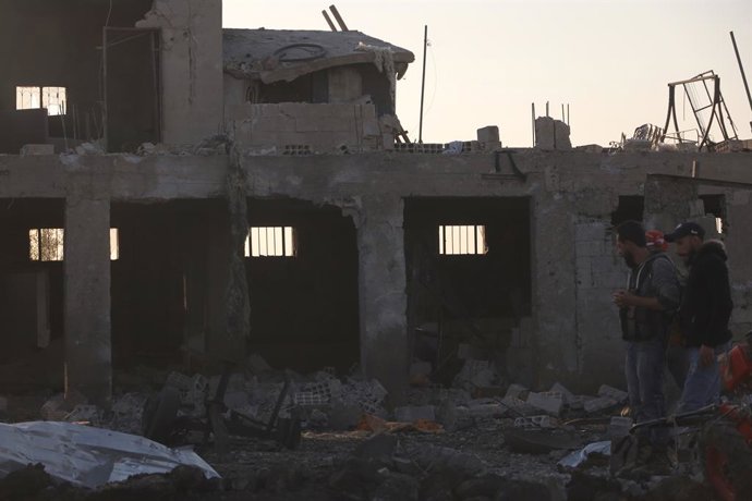 SWEIDA (SÍRIA), 2 de maio de 2025 -- Pessoas são vistas em frente a um prédio destruído por um suposto ataque de drone israelense em Sweida, no sul da Síria, em 2 de maio de 2025. Um ataque aéreo teve como alvo um local a oeste da província de Sweida, no 