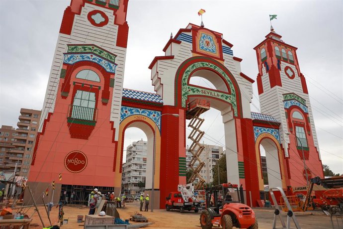 Varios trabajadores culminan la portada de la Feria de Sevilla.