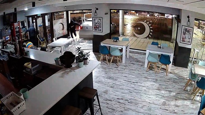 Ladrones entrando a un establecimiento hostelero de Asturias tras romper un cristal con un coche robado.