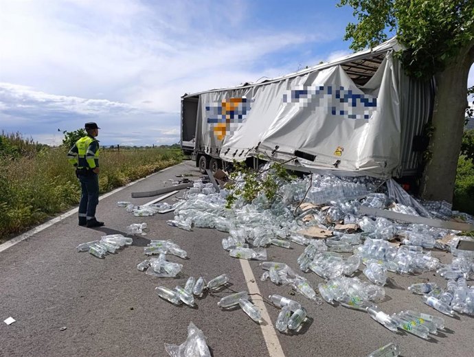 Imagen del camión accidentado con su carga esparcida sobre la carrertera.
