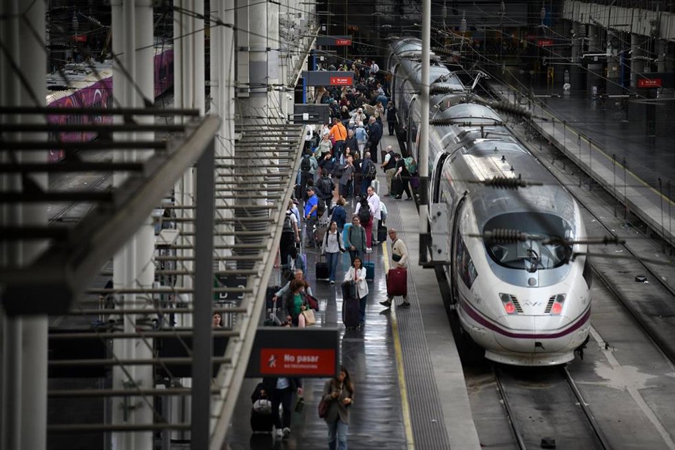 Varias personas con sus equipajes en la estación de tren de Atocha-Almudena Grandes.