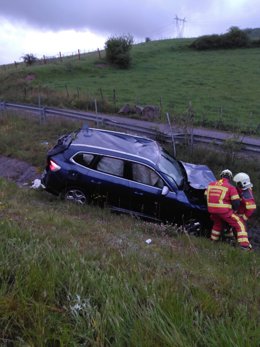 Bomberos voltean el coche volcado.