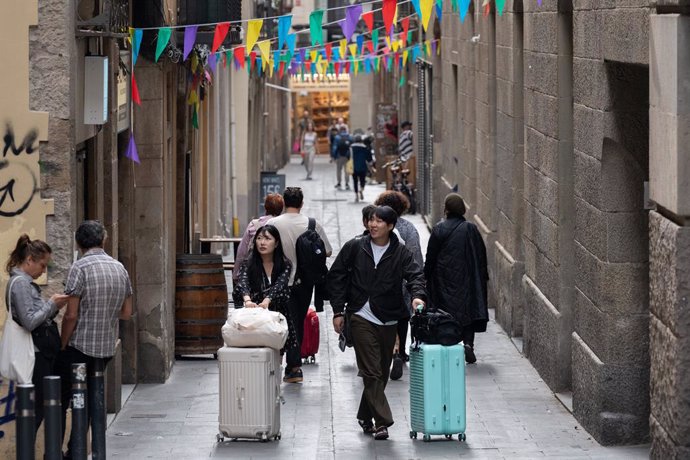 Archivo - Uns turistes amb les maletes al centre de Barcelona