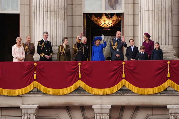 05 de maio de 2025, Reino Unido, Londres: O rei do Reino Unido, Carlos III, e a rainha Camilla, estão com membros da família real britânica na sacada do Palácio de Buckingham, enquanto assistem ao voo passado com as Flechas Vermelhas da Força Aérea Real e