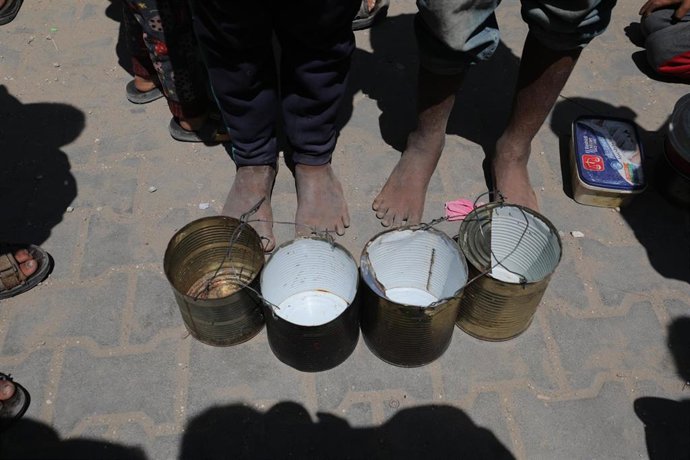 Imagen de archivo de palestinos esperando a recibir comida distribuida por organizaciones benéficas en el campamento de refugiados de Nuseirat, en el centro de la Franja de Gaza