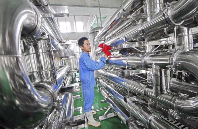 Archivo - Un empleado limpia unos equipos en una fábrica de vinos en Weifang, China, jul 28 2013. La demanda repuntó en el sector manufacturero de Estados Unidos en agosto, según datos publicados el martes, lo que junto a un informe que mostró un crecimie