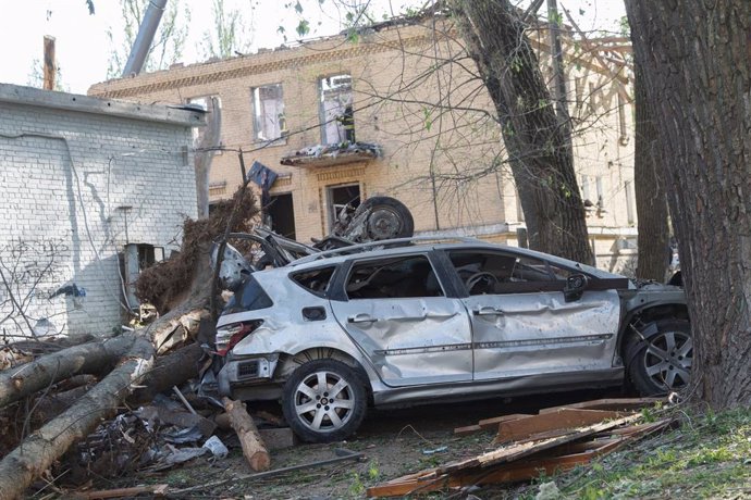 24 April 2025, Ukraine, Kiev: A crushed car is outside an apartment block in the Sviatoshynskyi district after a Russian missile strike on Kiev. Photo: -/Ukrinform/dpa