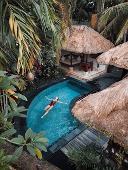 Mujer bañándose en la piscina de su hotel