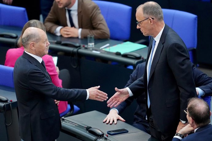 06 May 2025, Berlin: Acting Federal Chancellor Olaf Scholz shakes hands with Chancellor candidate Friedrich Merz during the second round of Chancellor election. Merz failed the first round of voting in the Bundestag. Photo: Kay Nietfeld/dpa