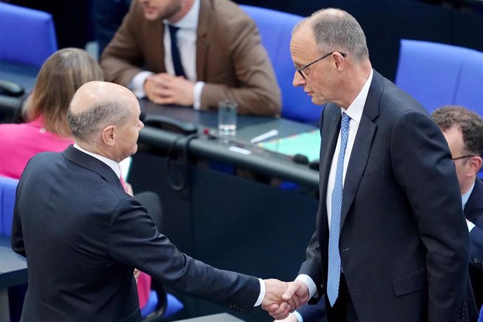 El recién elegido canciller de Alemania, Friedrich Merz, saluda al canciller saliente, Olaf Scholz.