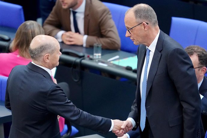 06 May 2025, Berlin: Acting Federal Chancellor Olaf Scholz shakes hands with Chancellor candidate Friedrich Merz during the second round of Chancellor election. Merz failed the first round of voting in the Bundestag. Photo: Kay Nietfeld/dpa