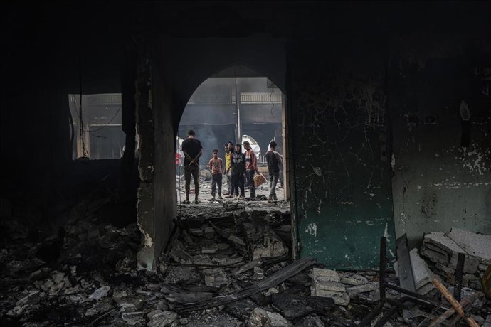 Un grupo de palestinos inspecciona los daños de un ataque israelí en la ciudad de Gaza