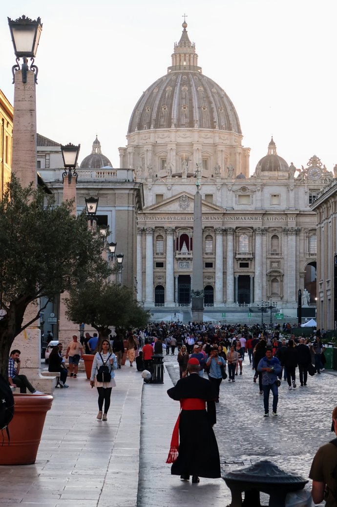 Un cardenal pasea entre decenas de turistas en la plaza de San Pedro.