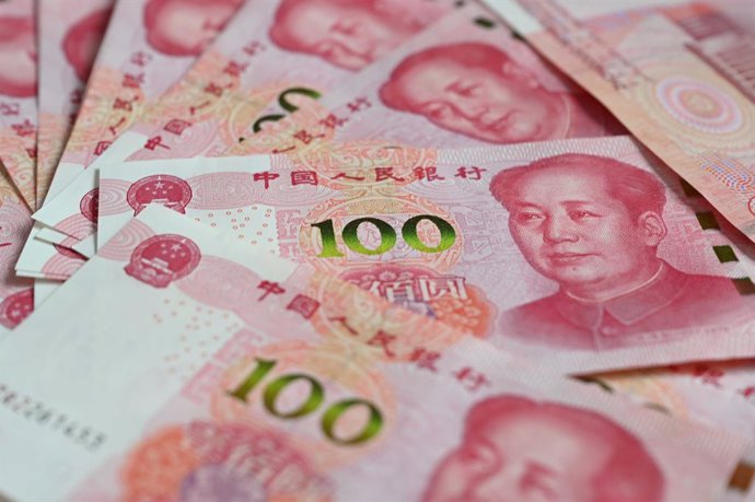 Archivo - FILED - 12 December 2023, China, Beijing: Several bills, each with a value of 100 Chinese yuan, lie on a table. Photo: Johannes Neudecker/dpa