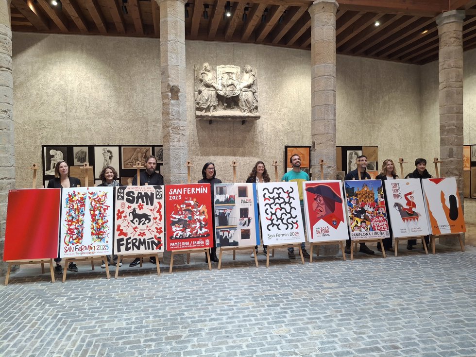 El jurado del concurso de carteles de San Fermín 2025 junto a las diez obras finalistas.