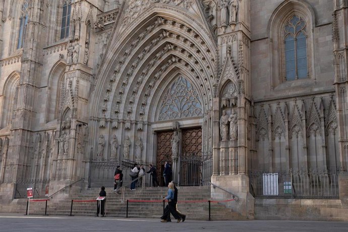 Archivo - Varias personas delante de la fachada de la Catedral de Barcelona, a 19 de diciembre de 2024, en Barcelona