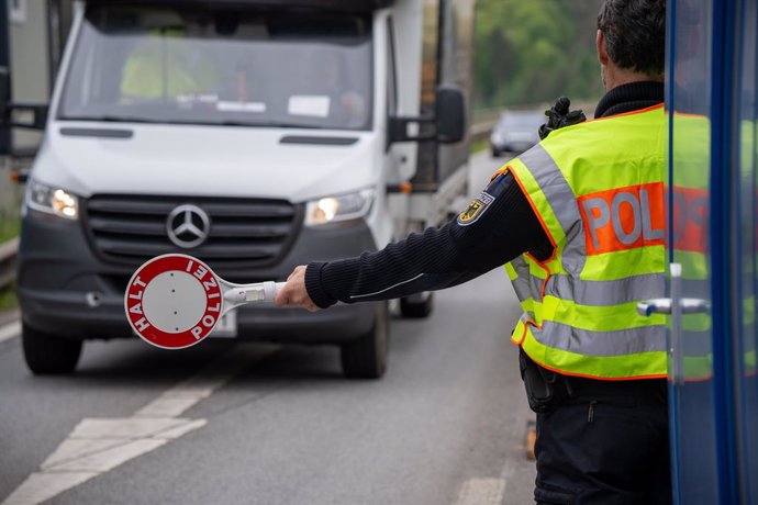07 May 2025, Rhineland-Palatinate, Trier: A police officer stops a van on the A64 motorway as Germany extends checks at its external borders. Photo: Harald Tittel/dpa