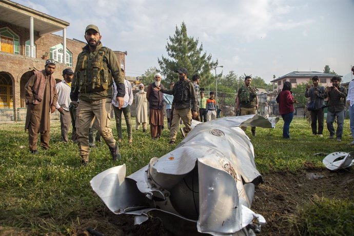 May 8, 2025, Srinagar, Jammu And Kashmir, India: Indian policemen and people look at a part of an unknown crushed aircraft in Wuyan near Indian-administered Kashmir's main city of Srinagar. India fired missiles at Pakistani territory early on May 7, killi