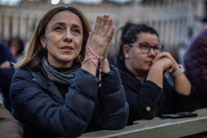 Una mujer reza mientras espera a que salga la primera fumata del Cónclave.
