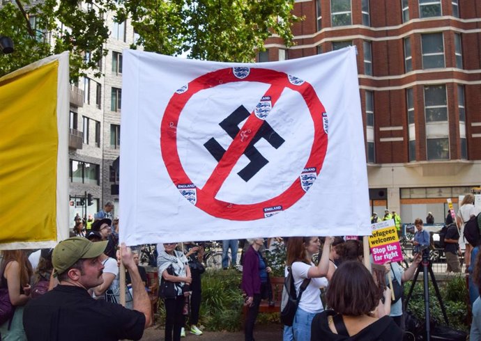 Archivo - Manifestantes sostienen una pancarta antinazi durante una concentración frente a las oficinas de Reform UK antes de marchar en Westminster contra Nigel Farage y la extrema derecha, en Londres, Reino Unido, el 10 de agosto de 2024.