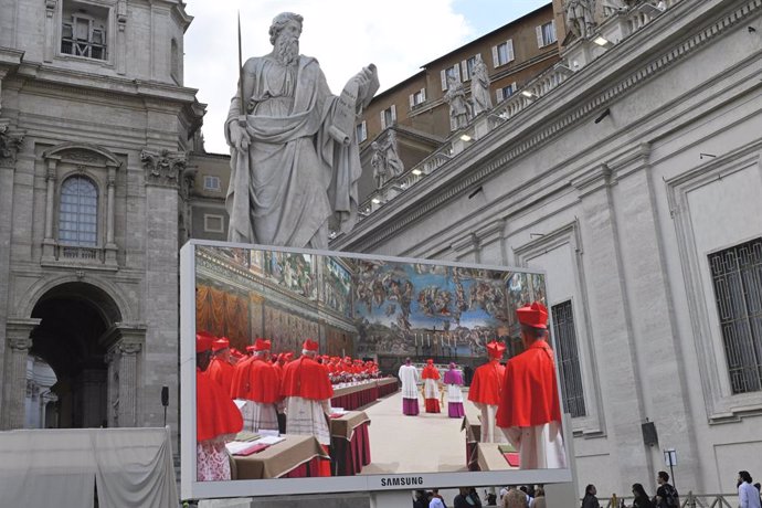 Una pantalla muestra imágenes de los cardenales antes de comenzar el Cónclave a puerta cerrada en la Capilla Sixtina, a 7 de mayo de 2025, en Ciudad de Vaticano (Vaticano). Antes de la celebración del Cónclave, los 133 cardenales electores llamados a eleg