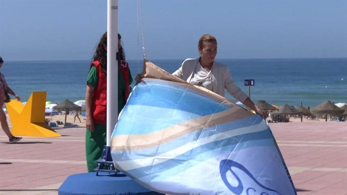 Archivo - La delegada territorial de Turismo en Cádiz, Tania Barcelona en la izada de la bandera azul en la playa de La Barrosa en Chiclana en 2024. Archivo.