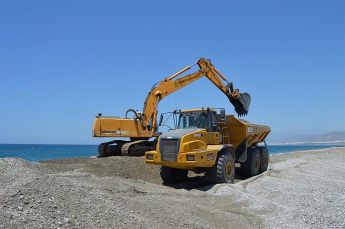 Maquinaria trabaja en las labores de aportación de arena en una playa del litoral de Almería.