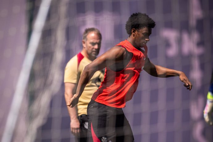 El jugador del FC Barcelona Alejandro Balde en el entrenamiento del 8 de mayo de 2025, ante la mirada de su entrenador, Hansi Flick