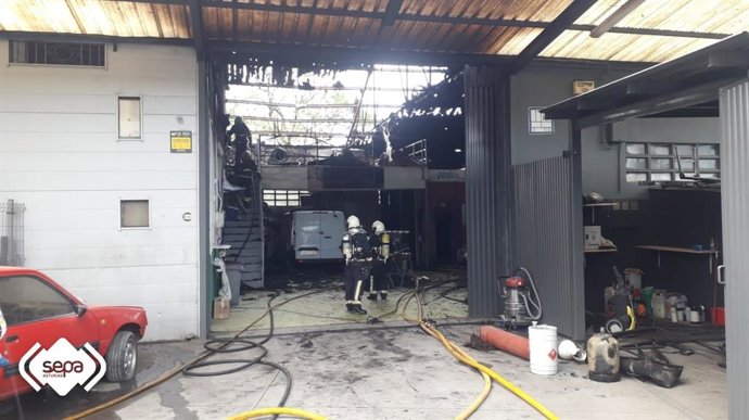 Los bomberos del SEPA sofocan el incendio declarado en una nave en Noreña.