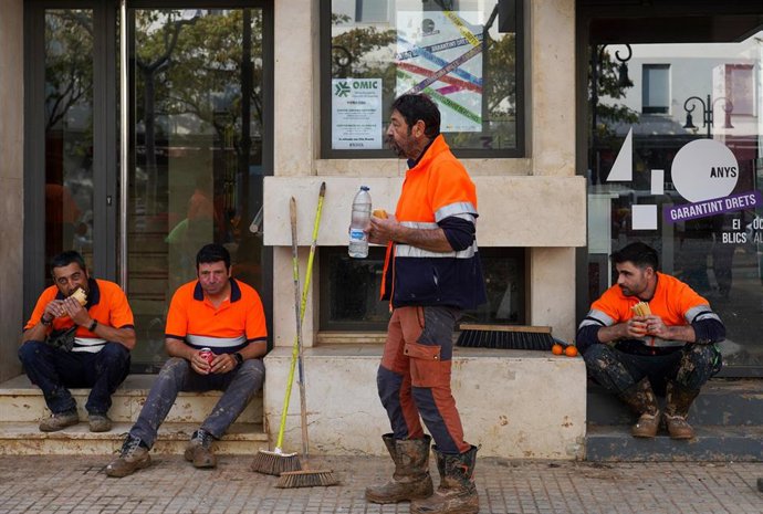 Archivo - Imagen de archivo de varios trabajadores descansando en Aldaia (Valencia) tras el paso de la dana.