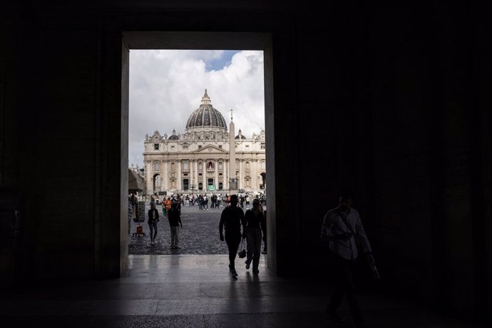 05 May 2025, Vatican, Vatican City: Italian police officers and journalists stand outside a guest house where non-Vatican cardinals are staying. The conclave to elect a new pope begins on Wednesday. On Tuesday, the cardinals meet for the last time to prep
