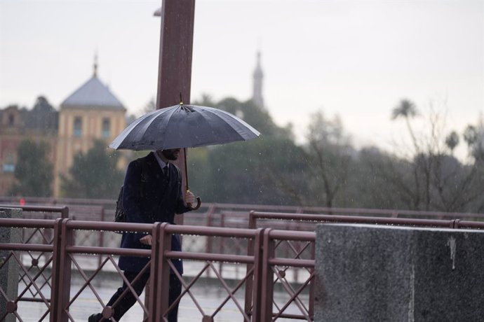 Archivo - Una persona se protege de la lluvia con un paraguas. A 03 de marzo de 2025, en Sevilla (Andalucía, España). Un total de seis provincias estarán bajo aviso por fenómenos meteorológicos este lunes en Andalucía. Lo más destacado es el riesgo de niv