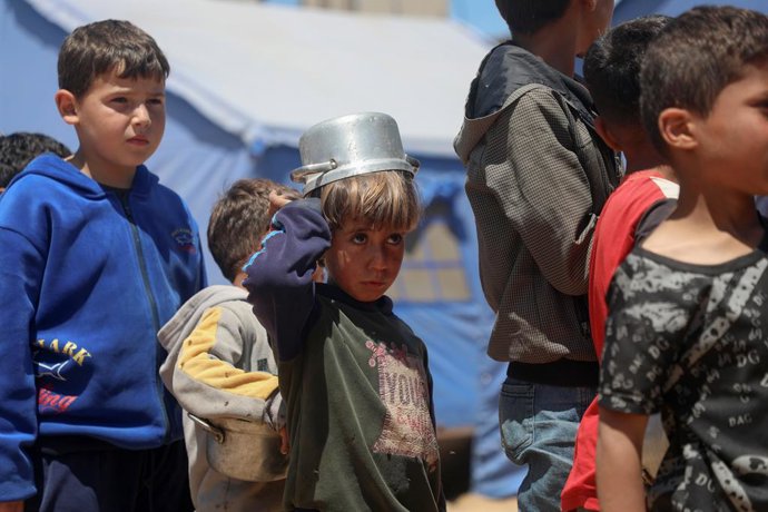GAZA, 20 de abril de 2025 -- Crianças palestinas esperam para receber alimentos gratuitos de um centro de distribuição de alimentos na Cidade de Gaza, em 19 de abril de 2025. A Agência das Nações Unidas de Assistência aos Refugiados da Palestina no Orient