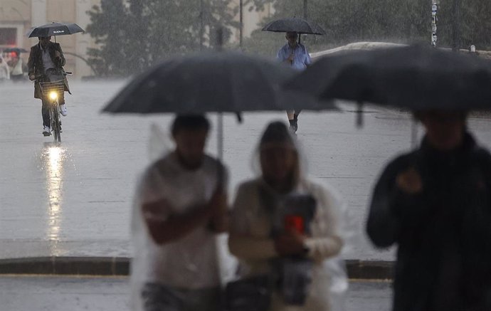 Archivo - Varias personas con paraguas bajo la lluvia, a 15 de septiembre de 2023, en València, Comunidad Valenciana (España).