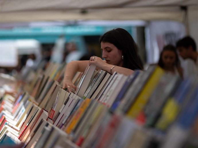 Dependienta colocando libros, durante la Diada de Sant Jordi 2025, a 23 de abril de 2025, en Barcelona, Cataluña (España).