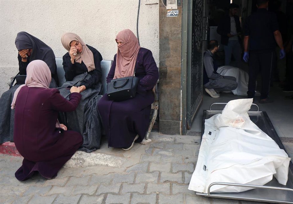 Palestinas junto a un muerto por un ataque del Ejército de Israel contra la ciudad de Gaza, situada en el norte de la Franja de Gaza (archivo)