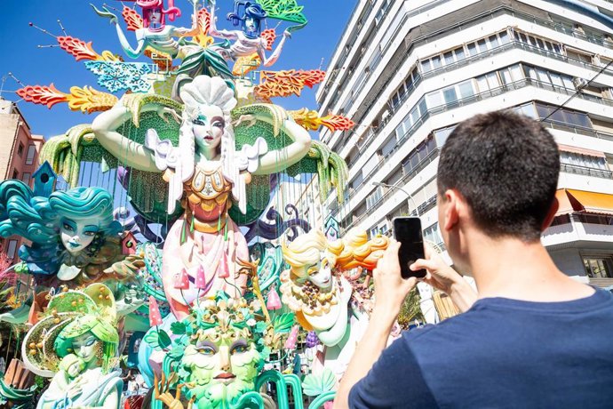 Archivo - Un hombre fotografía una falla de las Hogueras de San Juan, a 21 de junio de 2024, en San Juan, Alicante