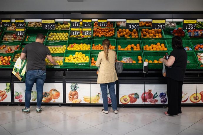 Varias personas realizan la compra en un supermercado  