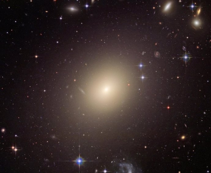La enorme galaxia elíptica ESO 325-G004 brilló 10.000 veces más cuando se formó que hoy. Este tipo de galaxias iluminó brevemente todo el universo y contribuyó a la radiación de fondo que podemos medir hoy.